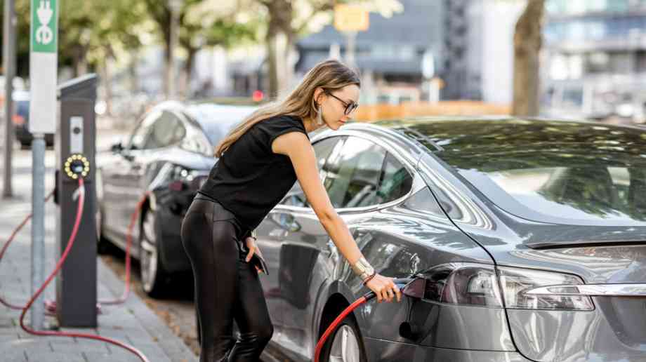 Woman charging car at kerbside